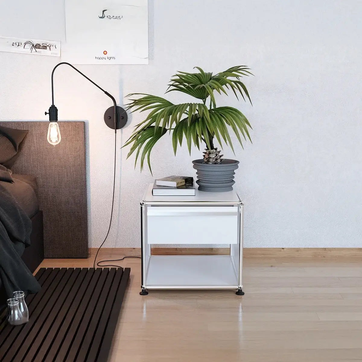 USM Haller Nachttisch mit Schublade in Weiß neben dem Bett, offenes Fach unten und verchromter Rahmen