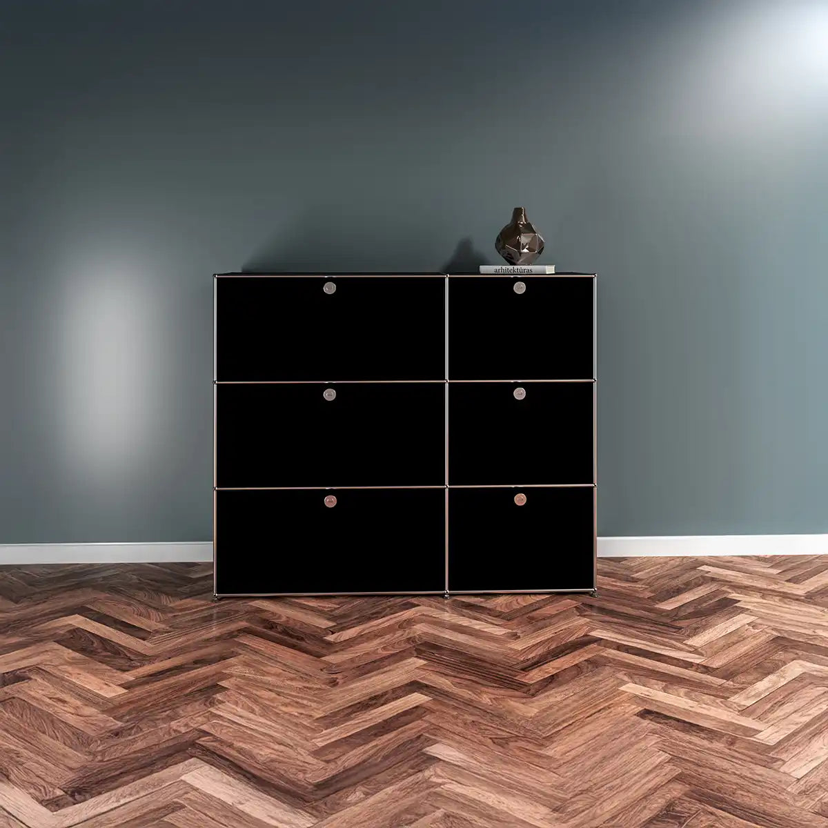USM Haller Sideboard in Schwarz mit sechs Klapptueren vor dunkler Wand, ruhige Front