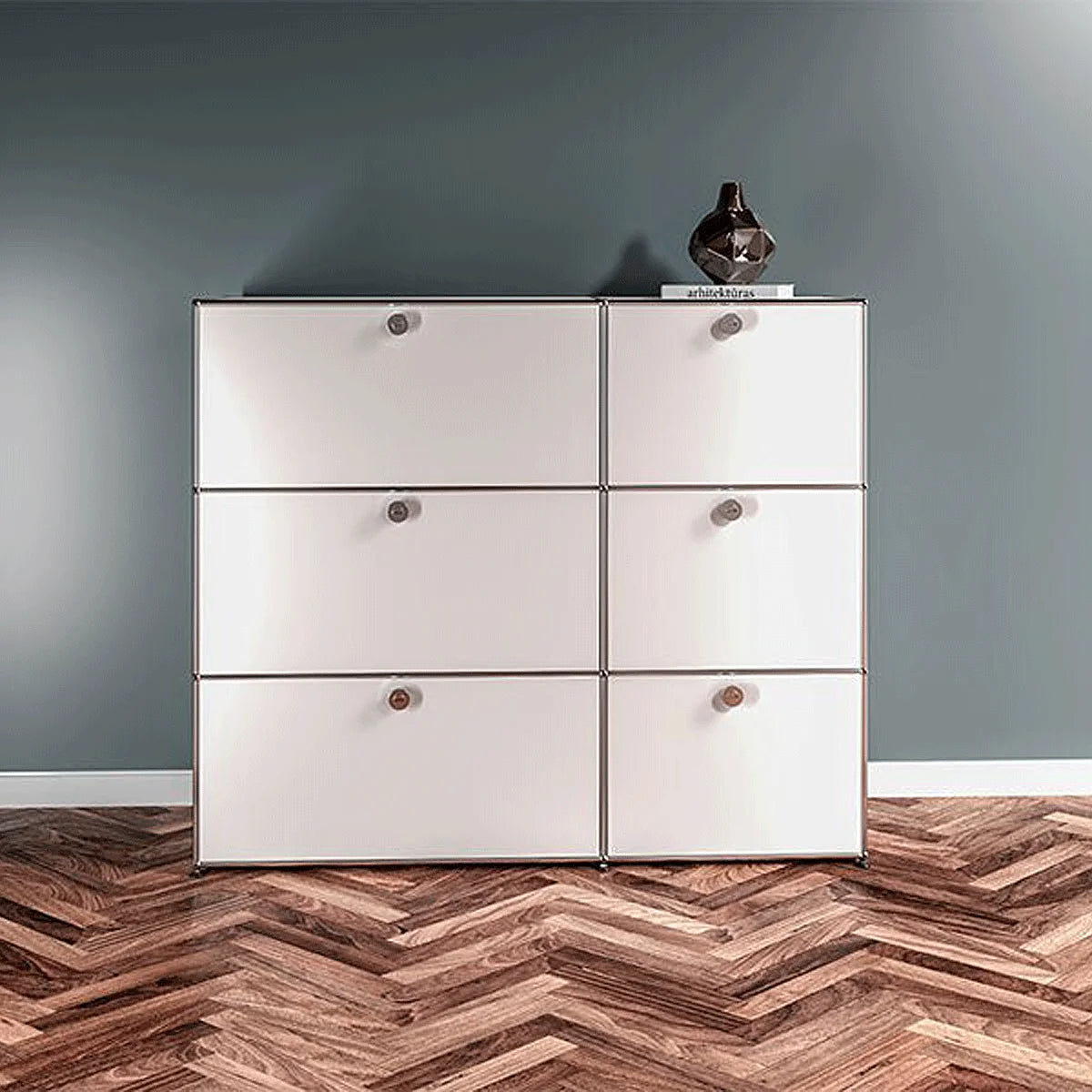 Weisses USM Haller Sideboard mit 6 Klapptueren, klare Linien und verchromter Rahmen im Wohnraum