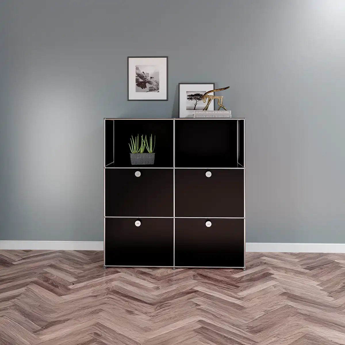 USM Haller Sideboard mit 4 Klapptüren in schwarz im Wohnzimmer mit Potraits an der Wand