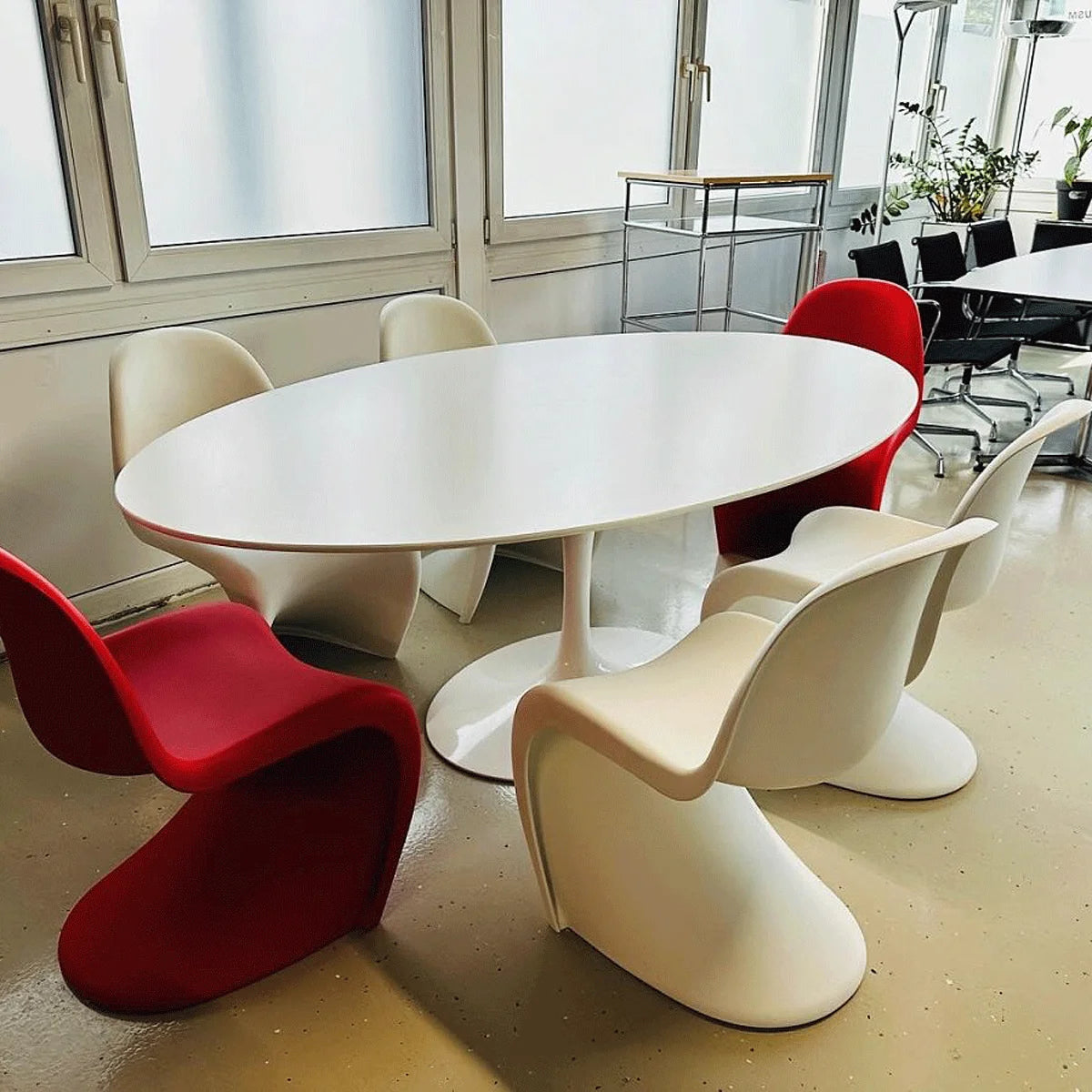 Ovaler Eero Saarinen Tisch mit roten und weißen Sitzen in einem USM Markt Showroom