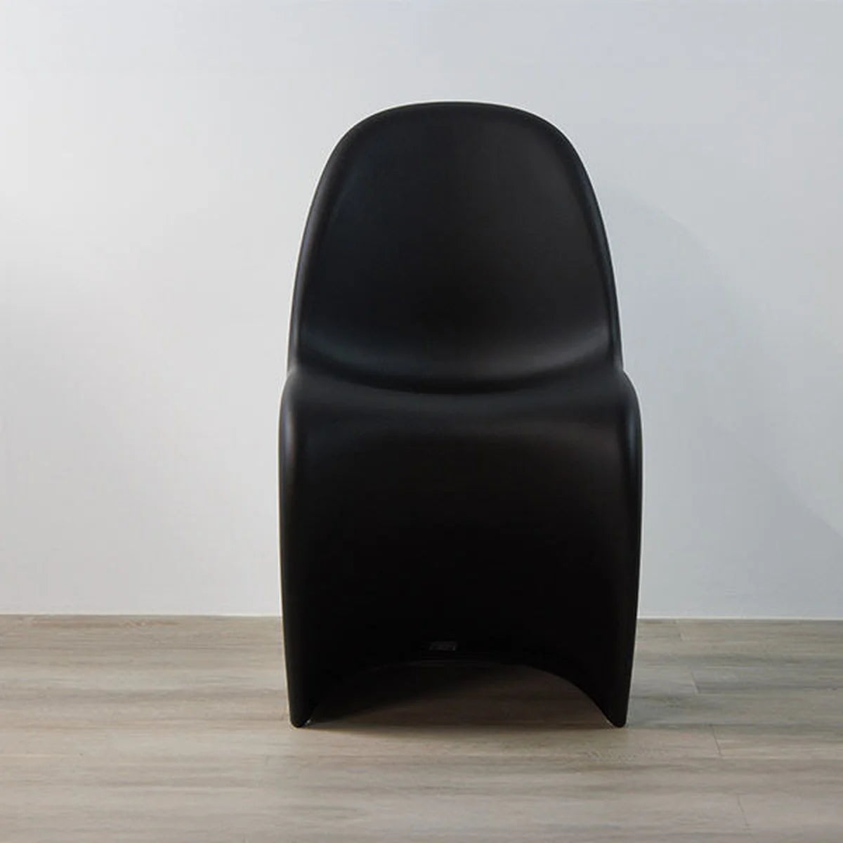 Vitra Panton Chair in Schwarz, Frontansicht der freischwingenden Kunststoffschale auf Holzboden