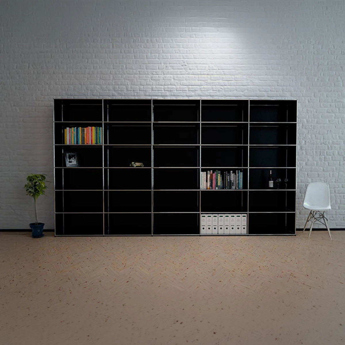 USM Haller Regal in Schwarz mit 30 Faechern, schraege Ansicht von rechts im Raum mit Ziegelwand
