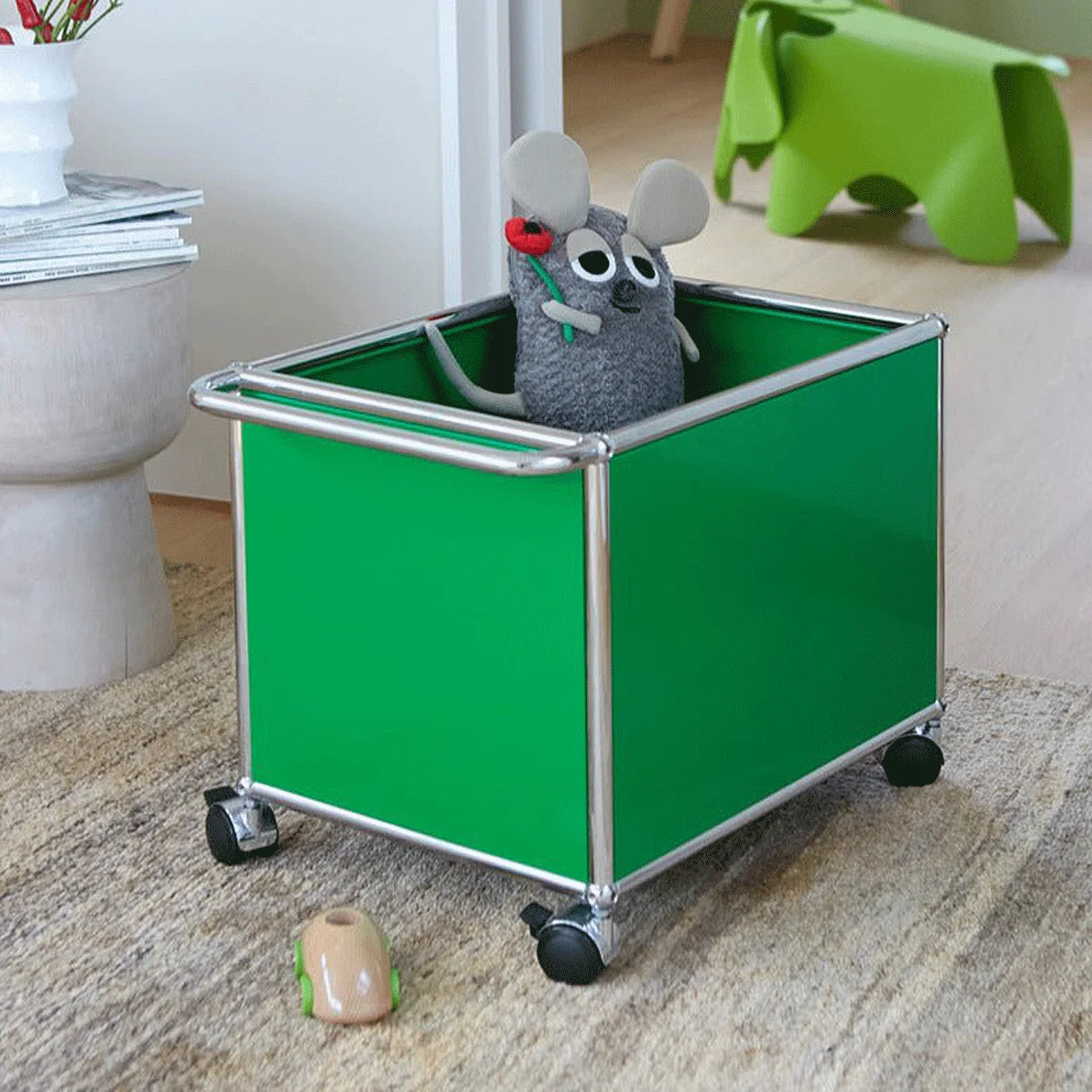 USM Haller Beistelltisch in grüner Farbe stehend in einem Kinderzimmer mit Spielsachen auf Rollen