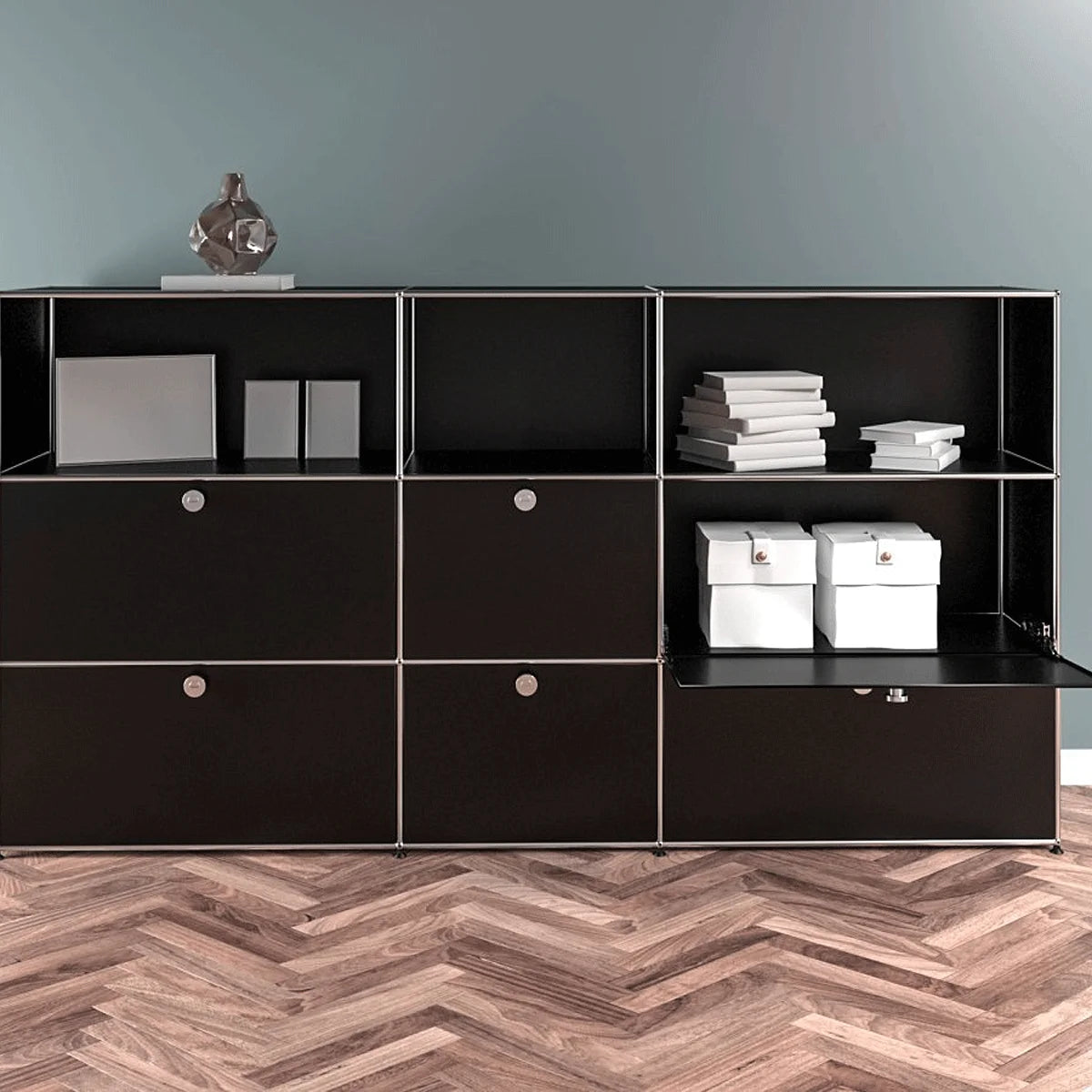 USM Haller Highboard 3x3 in Schwarz – Front, geöffnete Klapptür zeigt Stauraum für Ordner und Boxen