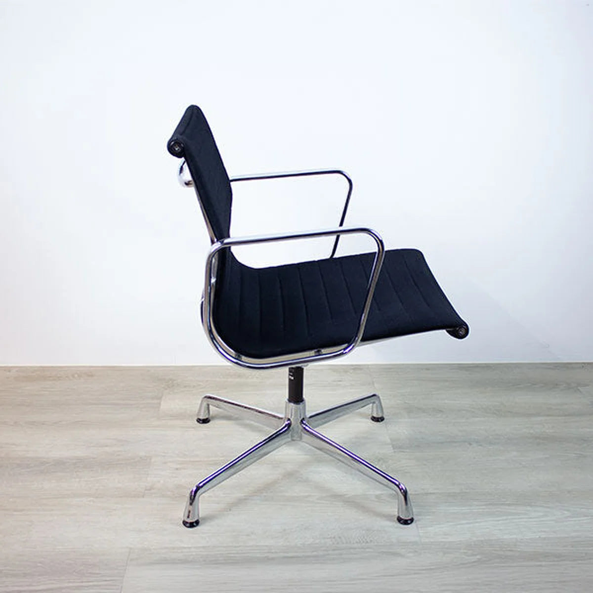 Schwarzer Vitra Alu Chair EA108 in schwarz auf Parkettboden seitliche Aufnahme