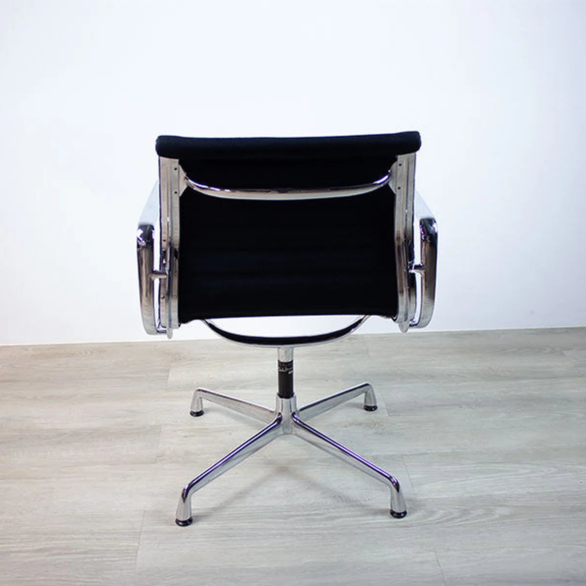 Schwarzer Vitra Alu Chair EA108 in schwarz auf Parkettboden Hintere Aufnahme