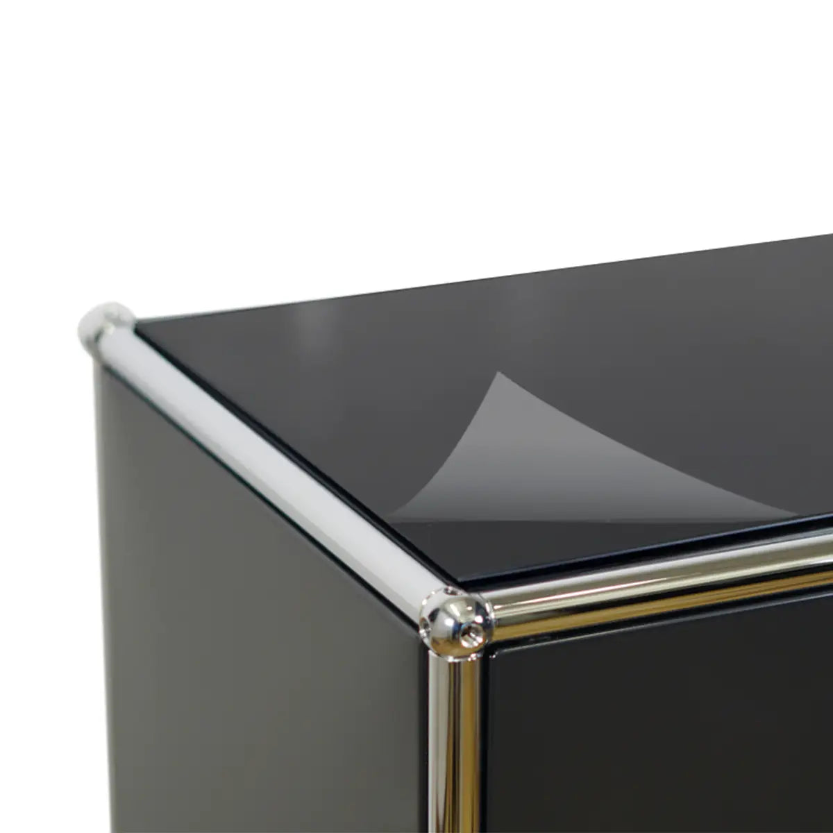 Detailansicht der Viloma Schutzfolie auf USM Haller Oberflaeche mit polierter Metallecke und glatter Folienkante
