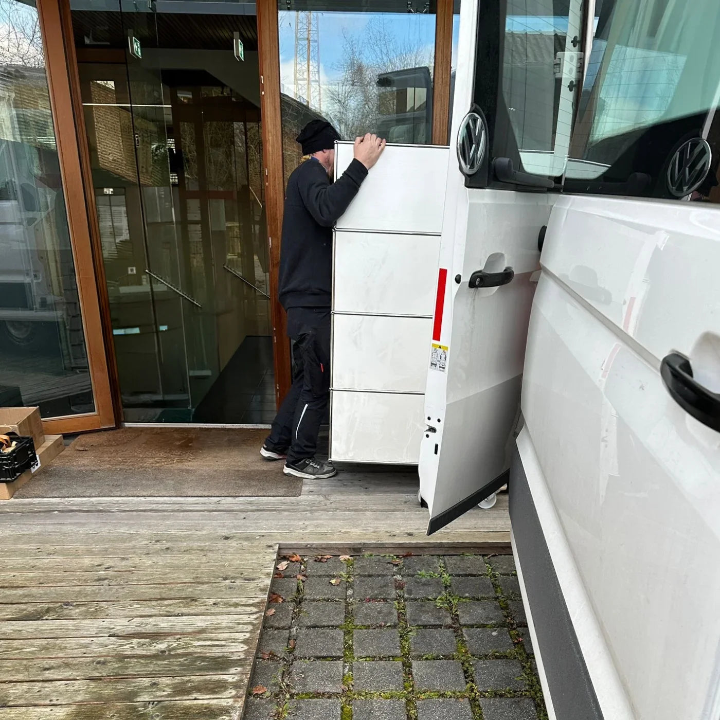 Mitarbeiter von USM Markt verladen ein USM Haller Sideboard in weiß in einen weißen Sprinter zur Abholung für Ankauf von USM